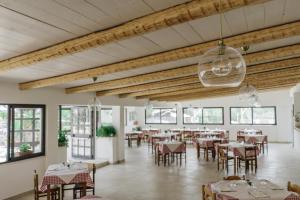 a dining room with tables and chairs and windows at Hotel Santa Rosalia in Marina di Camerota