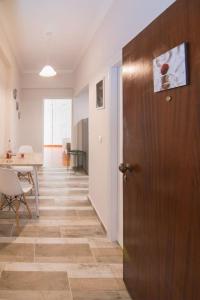 a hallway with a wooden door and a dining room at Cherry Apartment Corfu in Corfu