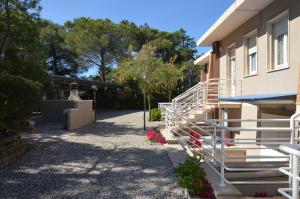 a building with white railings and flowers in a yard at Le tre caravelle S Maria a soli 150m dal mare -WI-FI in Marina di Castagneto Carducci
