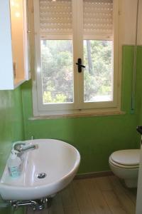 a bathroom with a sink and a toilet and a window at Le tre caravelle S Maria a soli 150m dal mare -WI-FI in Marina di Castagneto Carducci