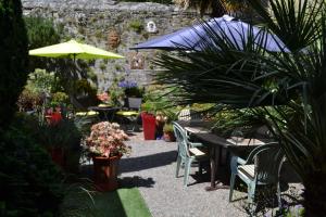 un patio con mesas, sillas y una sombrilla en Quimper Centre, en Quimper