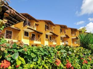 Merepe Residence في بورتو دي غالينهاس: مبنى أصفر مع مجموعة من الزهور