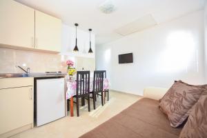 eine Küche und ein Wohnzimmer mit einem Sofa und einem Tisch in der Unterkunft Apartmani Bonik in Budva