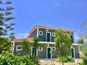 uma casa com varanda e palmeiras em Alegria Kefalonia em Kateleios