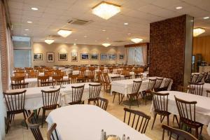 a dining room with tables and chairs in a room at Hôtel Sainte Suzanne in Lourdes