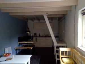 a kitchen with a white table and chairs in a room at Tinyhouse op Terschelling in Hoorn