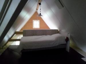 ホールンにあるTinyhouse op Terschellingのベッドルーム1室(ライト付きの屋根裏部屋のベッド1台付)