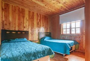 מיטה או מיטות בחדר ב-Cabañas Antulaf