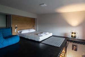um quarto com uma cama e um sofá azul em Bespoke House Athens em Atenas