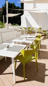 eine Reihe von Tischen mit gelben und weißen Tischen und Stühlen in der Unterkunft R2 Bahia Cala Ratjada - Adults Only in Cala Ratjada