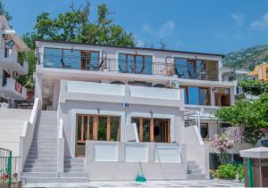 ein weißes Haus mit einer Treppe davor in der Unterkunft Jovan Apartments in Petrovac na Moru