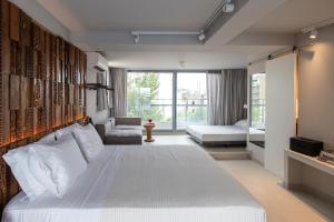 una camera con un letto bianco e una grande finestra di Bespoke House Athens ad Atene