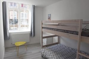 sypialnia z łóżkiem piętrowym i żółtym krzesłem w obiekcie La Grande Marée w mieście Dieppe