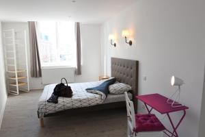 a bedroom with a bed and a red table at La Grande Marée in Dieppe