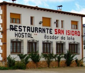 ein weißes Gebäude mit einem Schild an der Seite in der Unterkunft HOSTAL RESTAURANTE SAN ISIDRO in Quintanar de la Orden