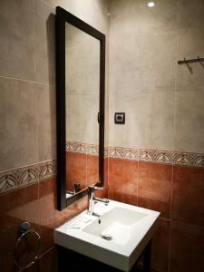 Un baño con un lavabo blanco y un espejo. en Apartamentos Cocó, en Ávila 37 fotos más