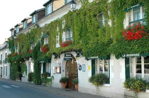 a building with ivy on the side of a street at Hotel La Roseraie in Chenonceaux
