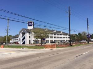 休斯頓的住宿－InTown Suites Extended Stay Houston TX - Stuebner Airline Rd，街道边的白色大建筑