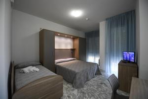 ジュリアノーヴァにあるResidence Gambrinusのベッド2台とテレビが備わるホテルルームです。