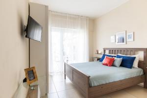 ナポリにあるToma la Lunaのベッドルーム1室(青と赤の枕が備わるベッド1台付)
