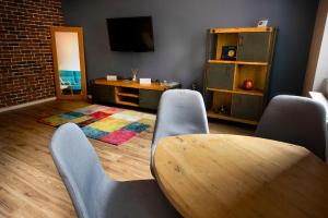 sala de estar con mesa, sillas y TV en Maniu Home, en Cluj-Napoca