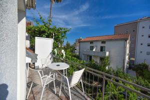 a balcony with chairs and a table on a building at Apartmani Bonik in Budva