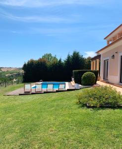 a yard with a swimming pool and a house at Villa with swimming pool in Golf Resort in Torres Vedras