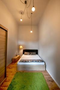 a bedroom with a bed and a green rug at Maniu Home in Cluj-Napoca