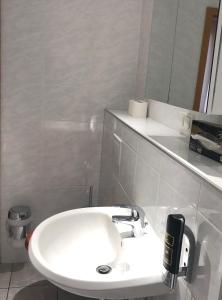 Baño blanco con lavabo y espejo en Hotel zum Schnackel in Mainz, en Wiesbaden