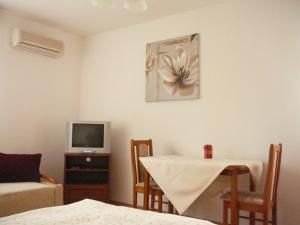 a living room with a table and a television at Almafa Apartman in Gyula