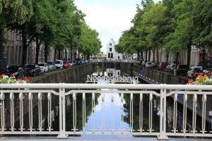 a canal in a city with cars parked at historic city apartment with private parking in Gouda