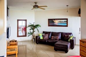 a living room with a brown couch and a ceiling fan at 9 Seesonnet Scottburgh in Scottburgh