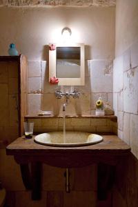 a bathroom with a sink and a mirror at I Trulli Di Acquarossa in Cisternino