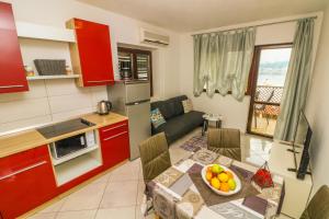 een keuken en een woonkamer met een tafel en een bank bij Apartments Andrea in Baška