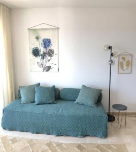 Un dormitorio con una cama con almohadas azules y una pintura en JACARANDA II Appartement, en Mandelieu-la-Napoule