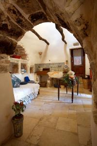 a bedroom with a bed and a table in a stone room at I Trulli Di Acquarossa in Cisternino