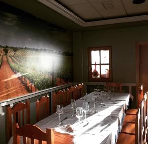 a long table in a restaurant with a painting on the wall at Camping Cubillas in Cubillas de Santa Marta