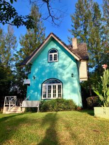 a blue house with a bench in the yard at Cottages @ Hill Resort in Mu Si