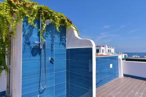 a blue tile bathroom with a shower at Rosanna Maison in Ischia