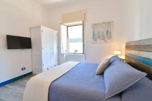 - une chambre avec un grand lit et une télévision dans l'établissement Rosanna Maison, à Ischia