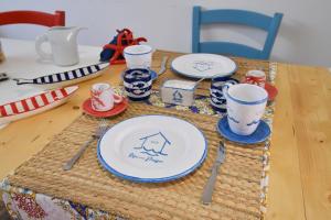 a table with plates and utensils on top of it at Rosanna Maison in Ischia