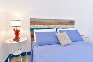 a bedroom with a blue bed with a wooden headboard at Rosanna Maison in Ischia