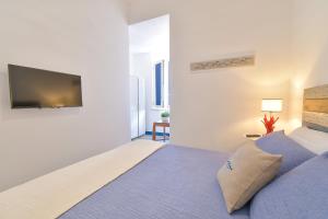 a bedroom with a bed and a flat screen tv at Rosanna Maison in Ischia