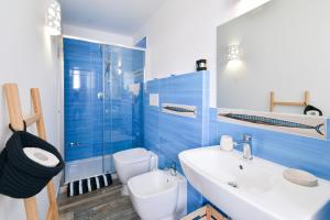 a blue bathroom with a sink and a toilet at Rosanna Maison in Ischia