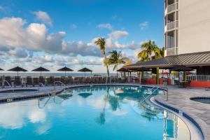 a swimming pool at a resort with palm trees at Diamond Head Beach Resort in Fort Myers Beach