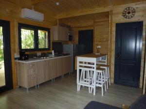a kitchen with a counter and stools in a cabin at DES BRANCHES & VOUS in Châteauneuf-sur-Isère