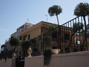 a building with a fence with potted trees on it at Viaggio in Sicilia B&B in Gravina di Catania