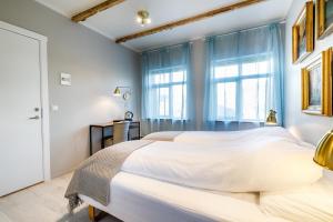 Un dormitorio con una gran cama blanca y una ventana en Englendingavík Homestay en Borgarnes