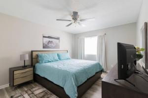 a bedroom with a bed with a ceiling fan and a television at Cute Condo in Rock Hill-57 in Rock Hill