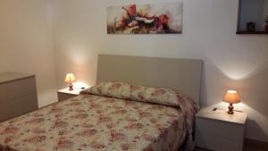 a bedroom with a bed and two night stands with lamps at Casa vacanze Mare in Parghelia